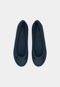 Ballerine blu navy realizzate in materiale morbido con punta tonda, caratterizzate da un piccolo fiocco sul davanti e una fodera interna texture.