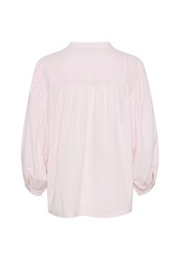 Light pink blouse with a textured, polka dot pattern. Features long, puffed sleeves and a gathered back design. Classic collar.