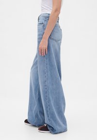 Lichtblauwe wijde jeans van denim, met een hoge taille en zijzakken. Gladde textuur met een ontspannen pasvorm en rechte silhouet.