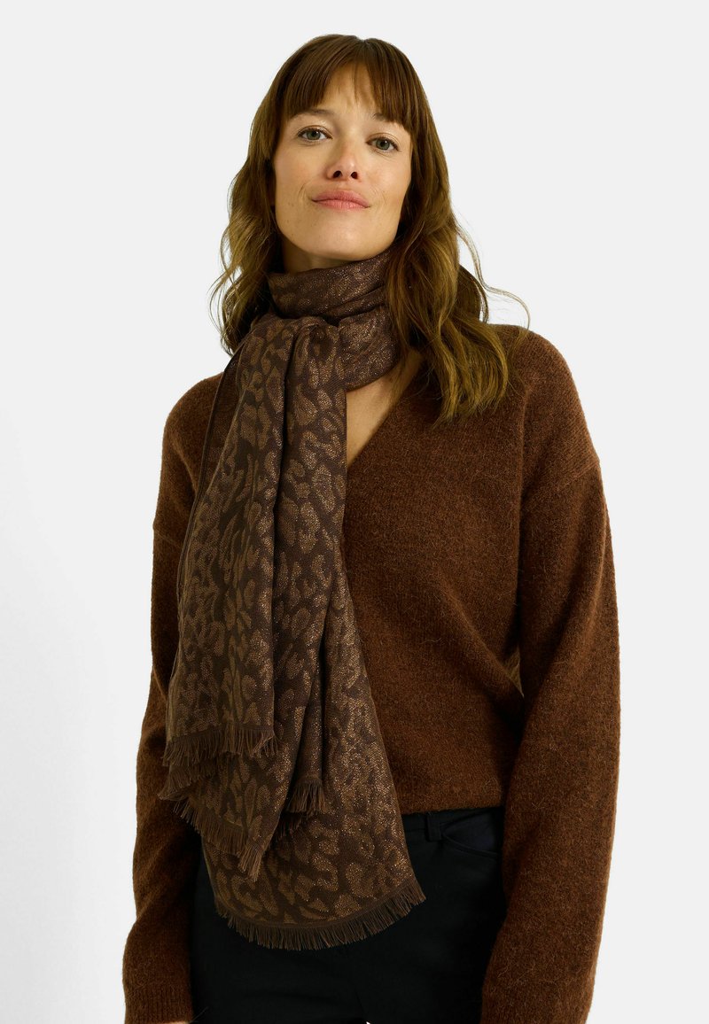 Bufanda marrón con estampado, hecha de tela suave, con diseño de estampado de leopardo y bordes deshilachados, colocada alrededor del cuello.