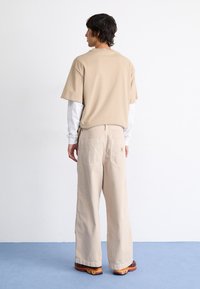 Carhartt WIP GARRISON PANT - Džíny Relaxed Fit - tonic stone dyed
