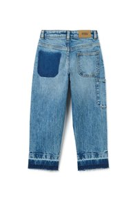 Jeans de mezclilla azul con un acabado desgastado, que presentan un parche oscuro de mezclilla en el bolsillo trasero, piernas recortadas y un dobladillo deshilachado.