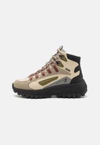 High-top hiking boots in beige and olive with red accents, textured rubber sole, metal eyelets, and multi-color laces.