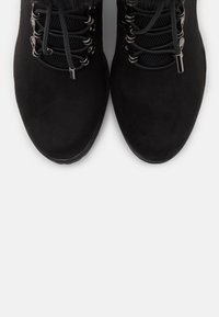Stivali alla caviglia in suede nero con colletto imbottito, linguetta in rete e asole metalliche per i lacci, dotati di una suola testurizzata per una presa migliore.