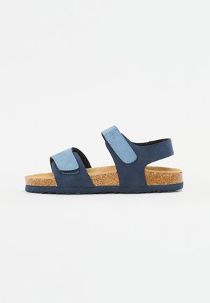 Sandali in suede blu navy e azzurro chiaro con due cinturini regolabili, soletta in sughero e suola in gomma testurizzata per una maggiore aderenza.