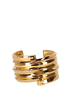 Bracciale rigido in tono oro con fasce stratificate e attorcigliate e piccoli dettagli con fibbia quadrata su sfondo bianco.