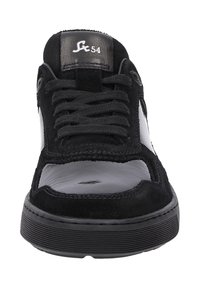 Baskets noires avec une tige en daim et un embout en cuir brillant, avec un design à lacets et une semelle en caoutchouc noir texturé.