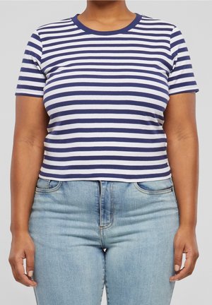Koszulka w paski w kolorach granatowym i białym, z krótkimi rękawami i okrągłym dekoltem. Połączona z jasnoniebieskimi jeansami z wysokim stanem.