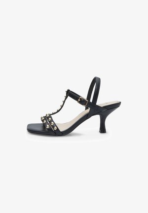 Sandale à talon noire avec un design à T, des accents de clous dorés et un orteil carré. Le matériau semble lisse avec une finition brillante.