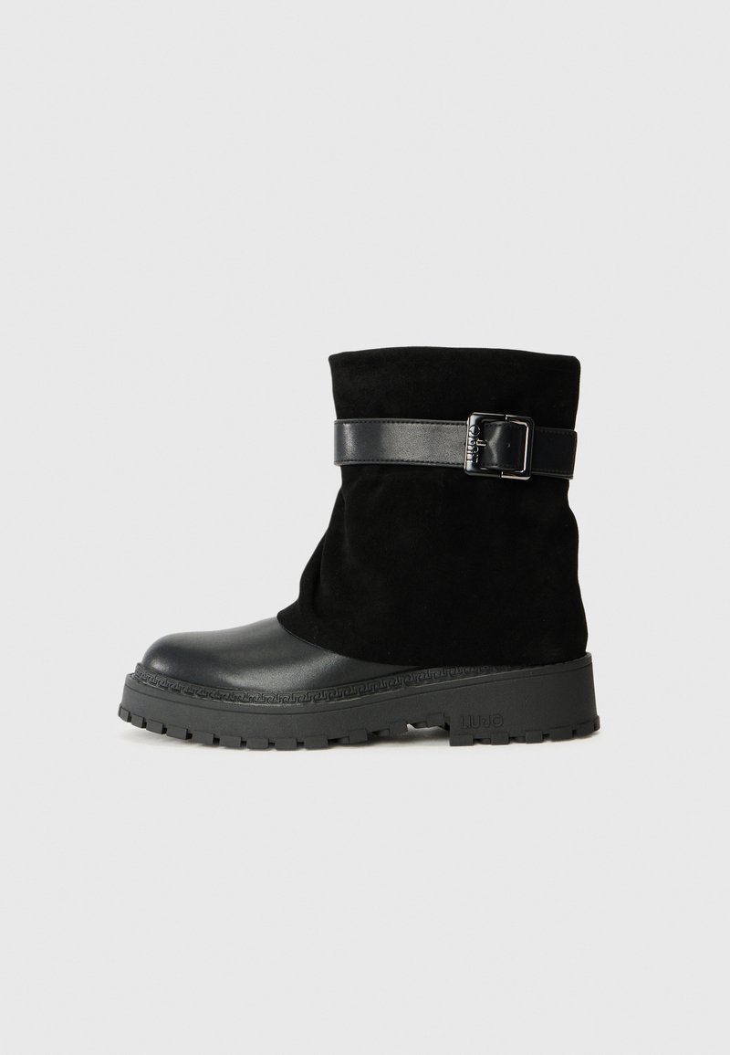 Schwarze Knöchelboots mit einem Obermaterial aus Wildleder und einer glatten Lederzehe. Sie verfügen über einen schwarzen Lederriemen mit einer Schnalle und einer strukturierten Gummisohle.