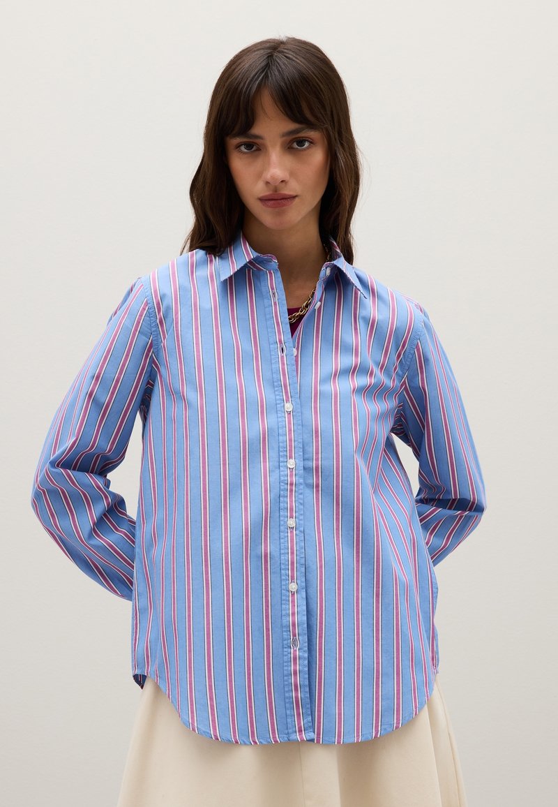 Camisa a rayas azul con rayas verticales rosas y blancas, con botones en la parte delantera, mangas largas, dobladillo redondeado, hecha de tela ligera.