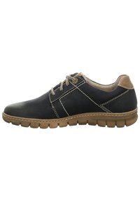 Scarpa nera in pelle con accenti color cuoio, cuciture dettagliate e una suola in gomma flessibile con un motivo testurizzato. Design classico con lacci.