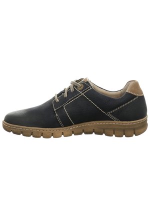 Chaussure en cuir noir avec des accents tan, des coutures détaillées et une semelle en caoutchouc flexible présentant un motif texturé. Design classique à lacets.