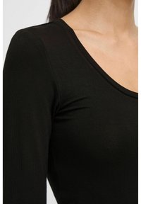 Black long-sleeve fitted top with a deep V-neckline, made of smooth, stretchy material. Features soft texture and minimal stitching details.