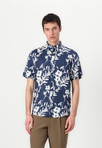Camisa de botones de manga corta en tejido azul marino con un patrón floral blanco; presenta un cuello y un pequeño logo en el pecho.