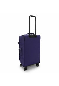 Valigia viola con manico nero retrattile, tasche laterali e quattro ruote per la mobilità. Tessuto liscio e forma rettangolare.