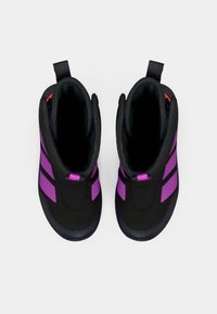 Zwarte enkelschoenen met paarse strepen, gladde textuur en een stevige zool. Kenmerken zijn een trekhaak aan de achterkant voor gemakkelijk aan- en uittrekken.