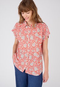 Camisa de manga corta con botones en color coral y patrón floral blanco, con un ajuste relajado y tejido suave. Adecuada para el uso casual.