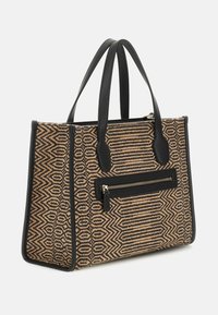 Tote bag gemaakt van geweven tan en zwart textiel met geometrische patronen, voorzien van zwarte leren accenten en een ritssluiting aan de voorkant.