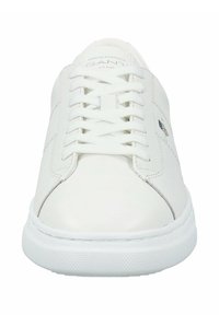 Sneakers bianchi in pelle con una finitura liscia, punta tonda, lacci piatti e suola in gomma testurizzata, caratterizzati da un design minimal e cuciture sottili.