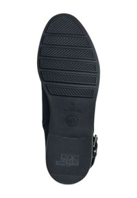 Semelle en caoutchouc noir avec un motif de traction texturé. Présente une empreinte de logo et un design flexible adapté à divers terrains.