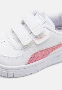Hvit lær sneakers med to borrelås, rosa PUMA-logo, teksturert sidepanel, og hvit gummisåle med horisontale riller.
