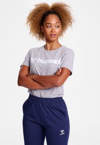 Grå bomulds t-shirt med "hummel" logo i hvid, parret med navy blå joggere med elastisk talje, der har det samme logo. Casual atletisk tøj.