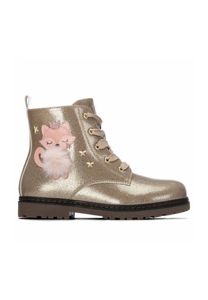 Bota infantil dorada y brillante con cordones beige, parche de zorro rosa con corona, estrellas y detalle de pompón esponjoso en el lateral.