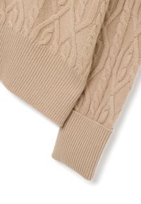 Suéter beige de punto trenzado con puños acanalados y patrones texturizados. El material es suave con un acabado acogedor, ideal para un uso casual.