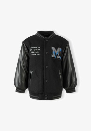 Fekete sportdzseki, amely gyapjú testtel, bőr ujjal, bordás mandzsettával és kék részletekkel, valamint hímzett "M" logóval rendelkezik.