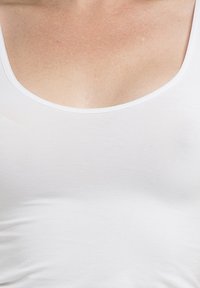 White tank top with a rounded neckline and smooth texture, featuring a fitted design that hugs the body shape.