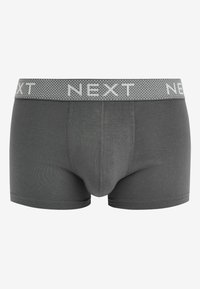 Pelēki kokvilnas bokseri ar zīmolu elastīgu jostasvietu, kurai ir punktiņu raksts un vārds "NEXT" baltajās burtos.