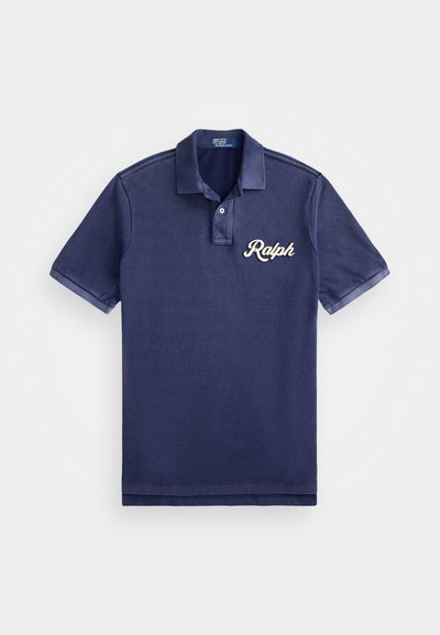 Granatowa koszulka polo z klasycznym kołnierzykiem, krótkimi rękawami i wyhaftowanym białym logo "Ralph" na lewej piersi. Miękka bawełniana tekstura.