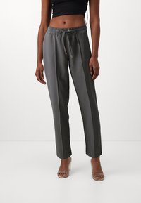 Pantalons gris avec taille élastique et cordon de serrage, dotés de rayures latérales verticales et d'une coupe droite. Fini avec une texture lisse.