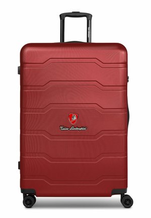 Maleta grande roja de carcasa dura con cuatro ruedas giratorias, asa negra extendida y logo de Tonino Lamborghini en el frontal.
