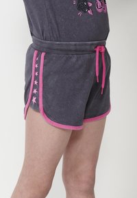 Shorts in cotone grigio con un cordino rosa, caratterizzati da un motivo a stelle lungo i lati e un bordo rosa a contrasto sull'orlo.