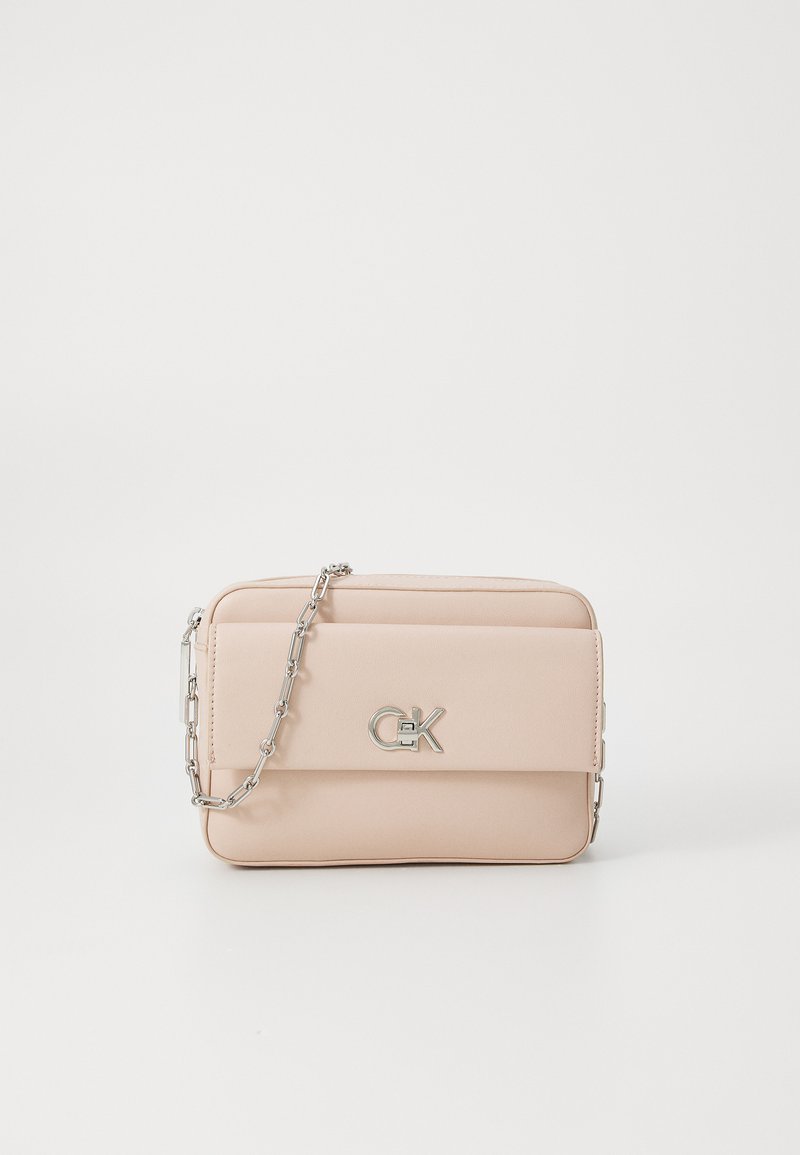 Svetloružová crossbody taška vyrobená z umelého koženého materiálu. Disponuje strieborným reťazovým popruhom a akcentom loga na prednej strane, má hladkú textúru a obdĺžnikový tvar.