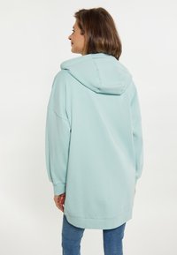 Felpa con cappuccio di colore azzurro chiaro, dalla vestibilita' oversize, maniche lunghe e orlo a coste. Tessuto morbido e design casual, adatto per un look rilassato.