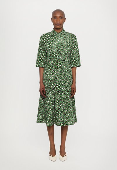 Grün gemustertes Kleid mit durchgehender Knopfleiste, halblangen Ärmeln und A-Linien-Rock. Verfügt über ein kreisförmiges Design in Weiß und dunkelgrün.