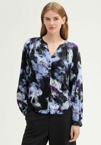 Blusa multicolore con base nera e motivi astratti blu e viola. Maniche lunghe, chiusura frontale con bottoni e scollatura a V.