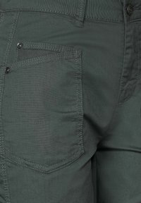 Grå, texturerade tygbyxor med en klassisk passform. Har en sidoficka med knappstängning och förstärkt sömnad längs sömmarna.