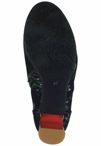 Black velvet shoe sole with floral texture, red accents, and a small heel. Size 37 marked on the sole. Circular pattern on the bottom.