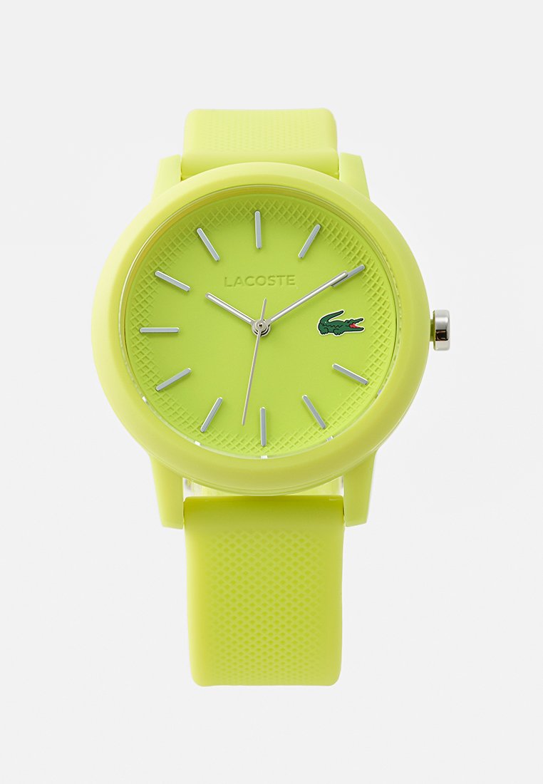 Zielono-limonkowy zegarek Lacoste na nadgarstek z silikonowym paskiem, srebrnymi znacznikami godzin i wskazówkami oraz logo krokodyla o godzinie 3.