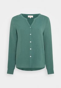 Blusa verde a maniche lunghe con scollo a V, chiusura a bottoni sul davanti e finitura testurizzata. Presenta un orlo curvo e un tessuto morbido.
