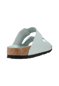 Sandal in verde menta con punta aperta, design a taglio, suola intermedia in sughero e suola esterna in gomma nera. Texture liscia con bordi arrotondati.