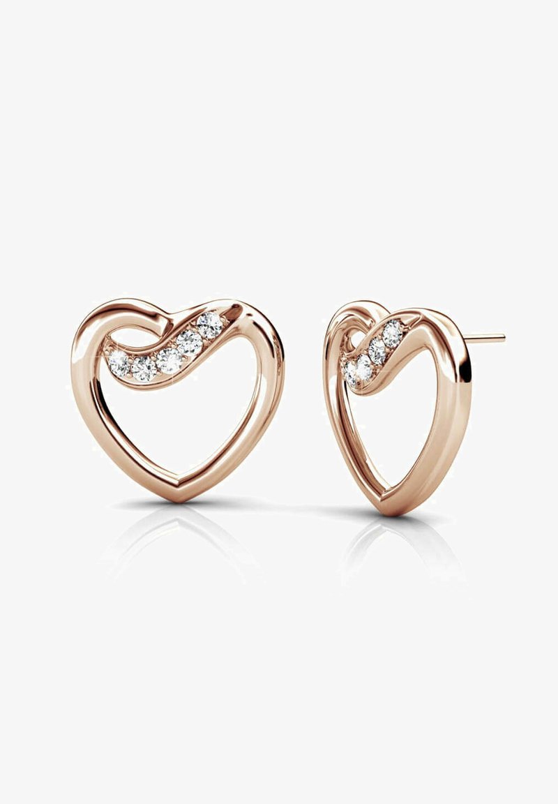 Orecchini a forma di cuore in oro rosa con un design attorcigliato, arricchiti da tre strass trasparenti incastonati su un lato, finitura lucida.