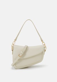 Hellbeige Ledertasche mit strukturiertem Finish, einem Oberhandgriff, verstellbarem Schultertragegurt und goldfarbener Kettendekoration.