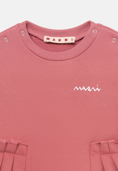 Rosa pink bomull sweatshirt med rund hals, synlige sømmer og sidelover. Har en hvit logo på framsiden.