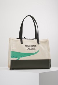 Borsa a tracolla in tela con grafica di un coccodrillo verde e manici neri. Riporta la scritta stampata "AFTER AWHILE CROCODILE." La base è di colore verde scuro.