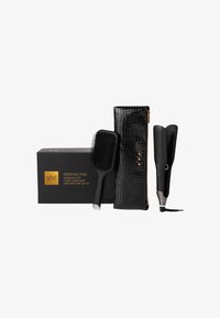 Zestaw prezentowy GHD Chronos Max zawiera szeroką prostownicę w kolorze czarnym, szczotkę paddle z czarną gumową rączką oraz teksturowaną czarną kosmetyczkę na zamek.
